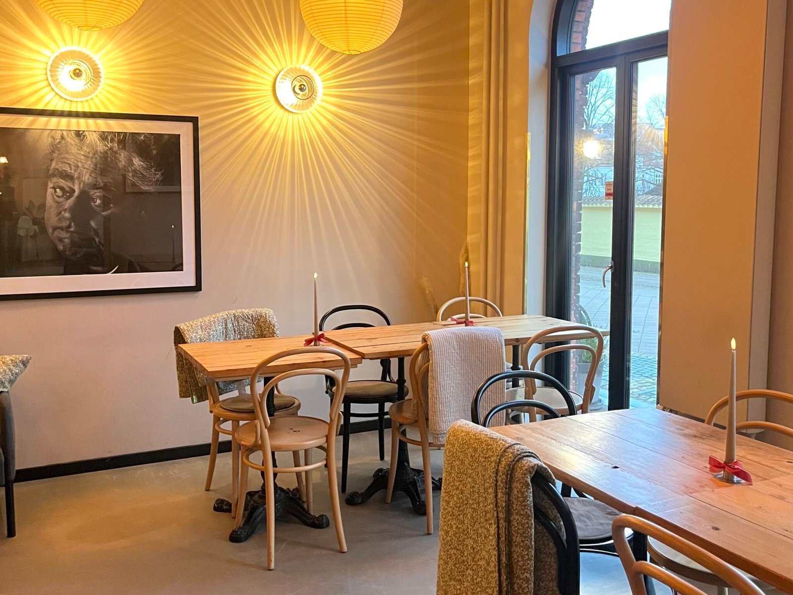 Det hyggelige interiør hos Stillestund med træstole, lys og varme lamper